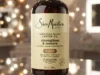SheaMoisture Jamaican Black Castor Oil shampoo bottle with gold pump on glass surface with bokeh lighting background